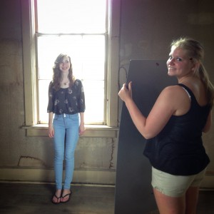 Photographer's assistant, Danielle, holds a plexiglass mirror for Hannah's senior pictures in our retro ballroom set.